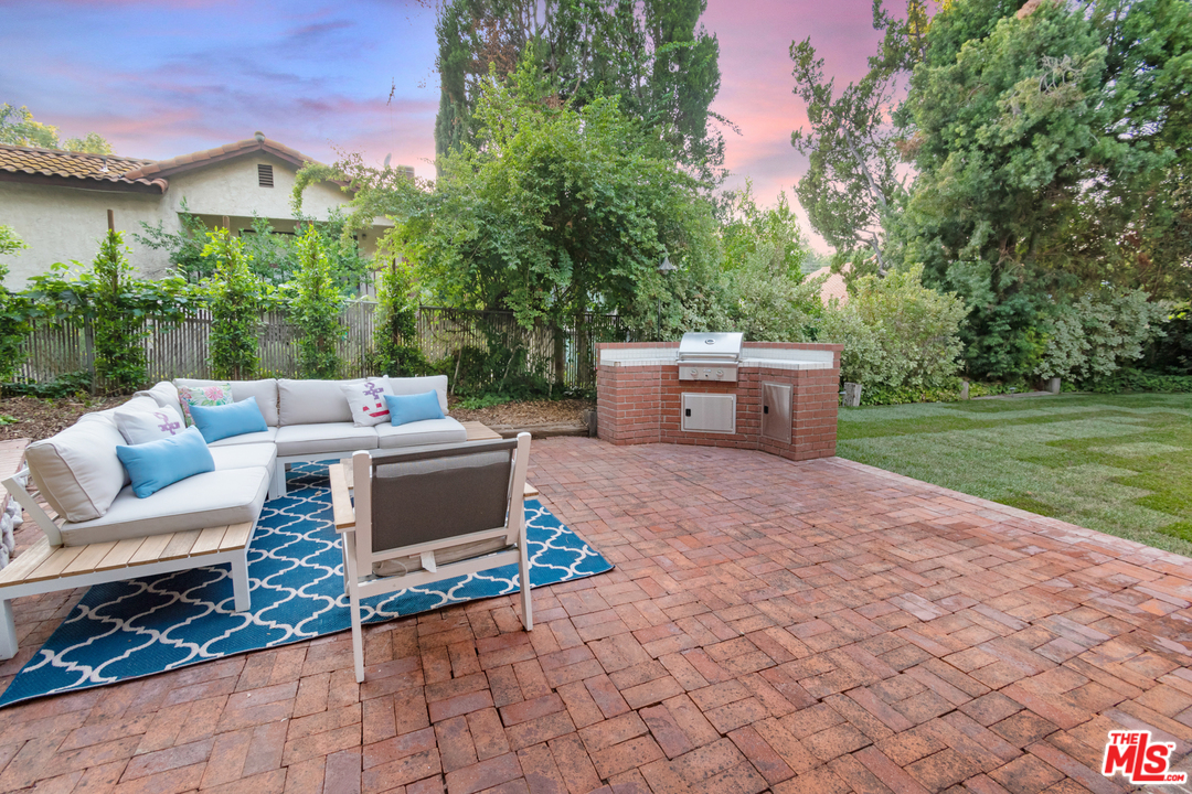 23030 Humming Bird Way Calabasas, CA 91302 - Photo 29 of 32 a view of a patio with couches and table and chairs and potted plants