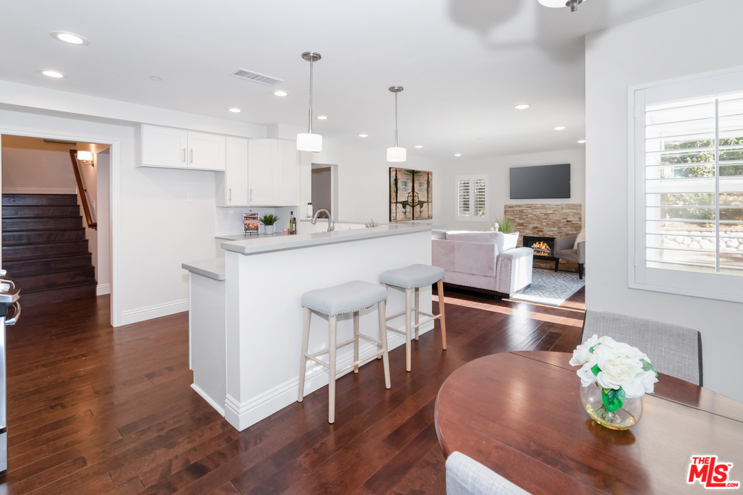 23030 Humming Bird Way Calabasas, CA 91302 - Photo 10 of 32 a kitchen with stainless steel appliances granite countertop a stove top oven a sink a refrigerator white cabinets and wooden floor
