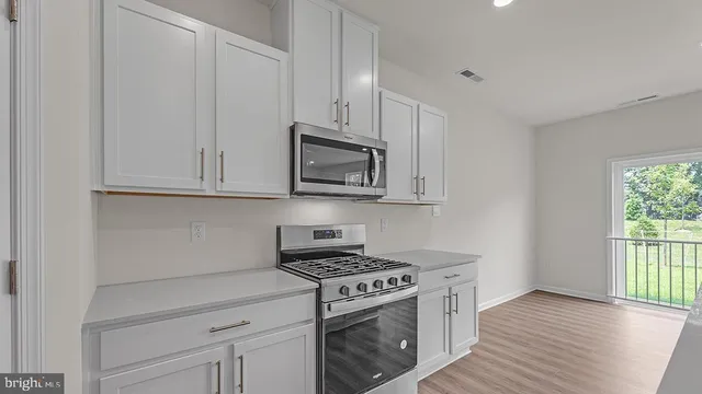 a kitchen with white cabinets and appliances