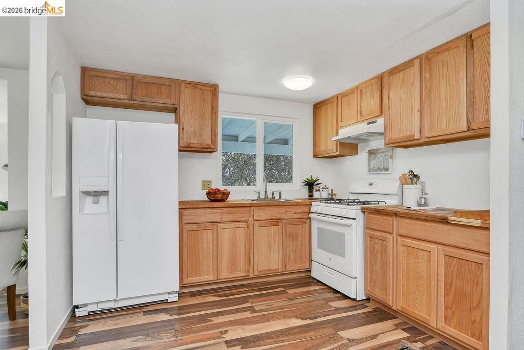 7550 Adams Road Valley Springs, CA 95252 - Photo 12 of 38 Kitchen featuring white appliances, light wood-style flooring, and light wood finish cabinetry