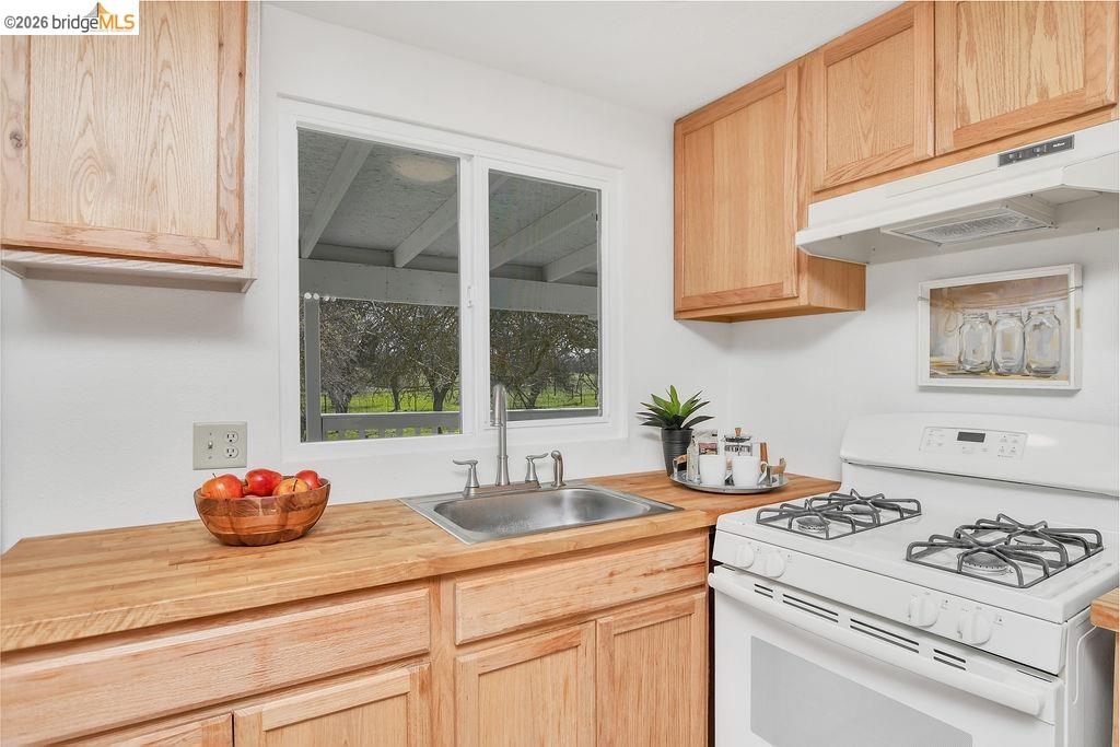 7550 Adams Road Valley Springs, CA 95252 - Photo 13 of 38 Kitchen with white gas range, light wood finish cabinetry, and butcher block countertops