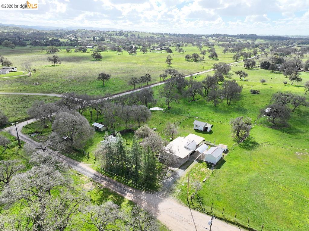 7550 Adams Road Valley Springs, CA 95252 - Photo 2 of 38 Overview of rural landscape with agricultural land and a tree filled landscape