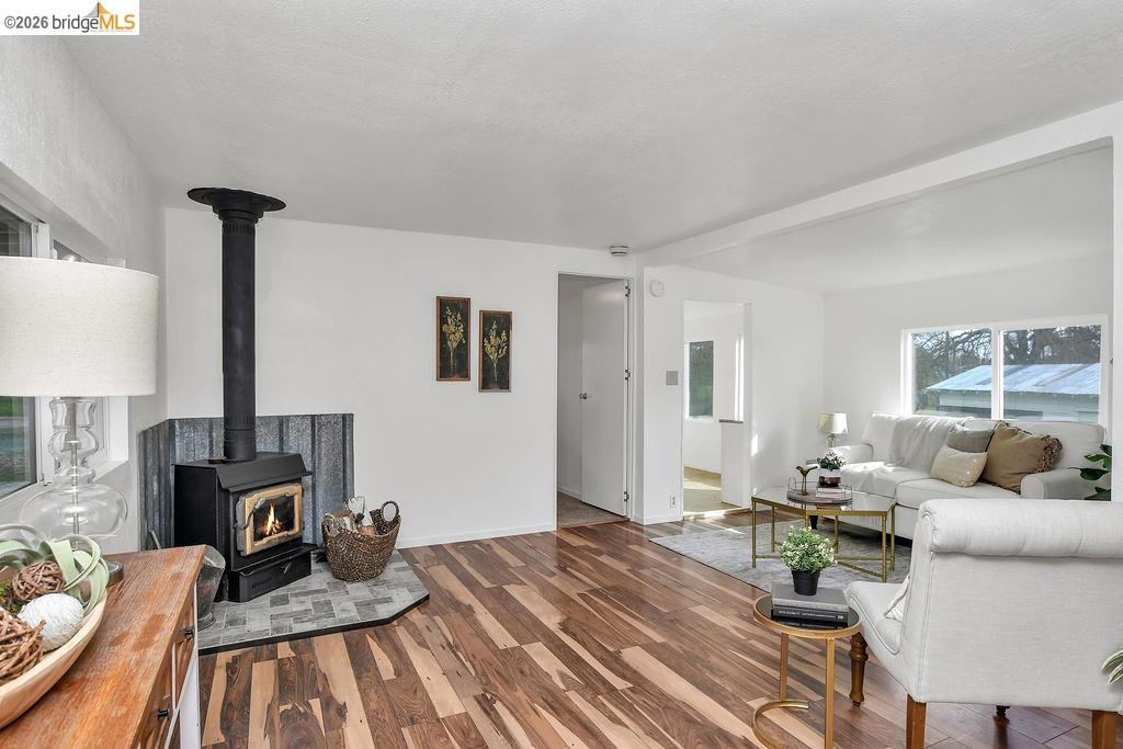 7550 Adams Road Valley Springs, CA 95252 - Photo 22 of 38 Living room with wood finished floors and a wood stove