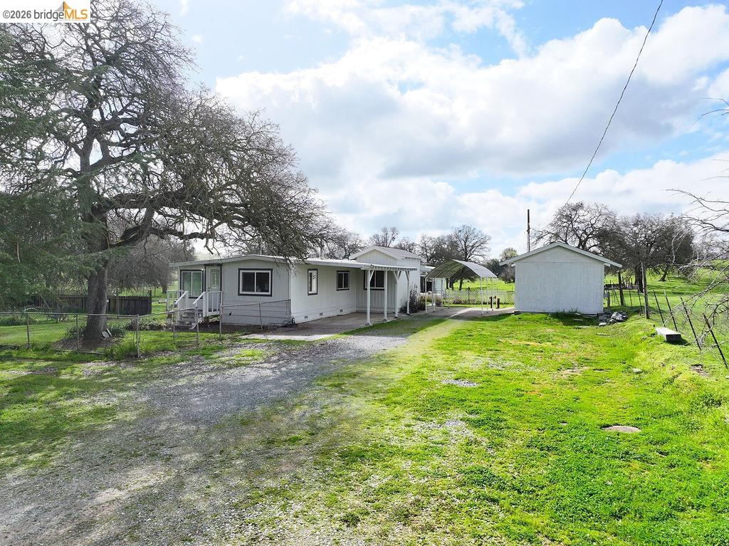 7550 Adams Road Valley Springs, CA 95252 - Photo 4 of 38 Back of house with a patio, driveway, and an outbuilding