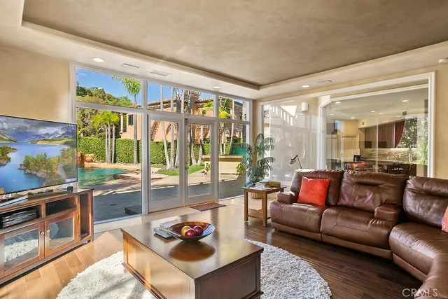 a living room with furniture a flat screen tv and a large window