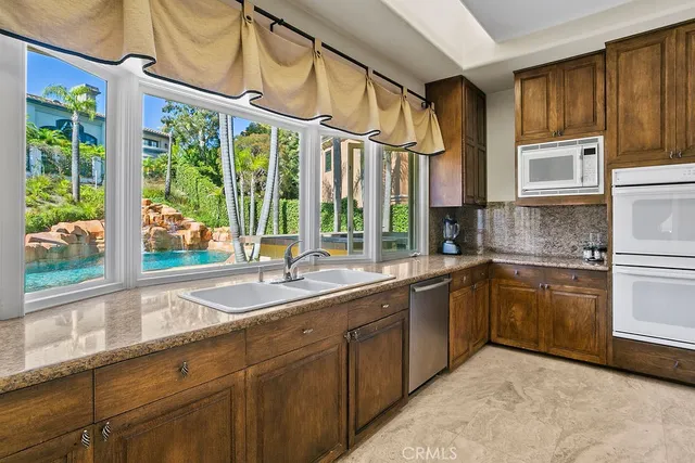 a kitchen with a sink and large windows