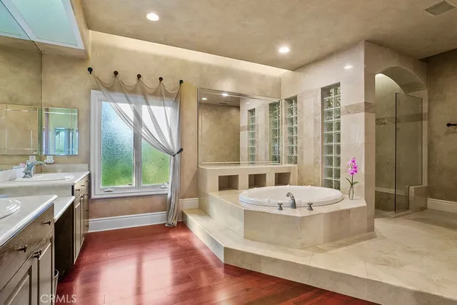 a large spacious bathroom with a tub sink shower and mirror
