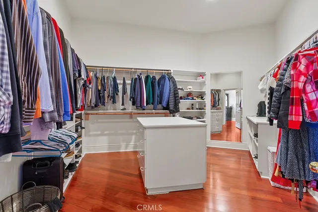 a view of walk in closet with clothes and shoes
