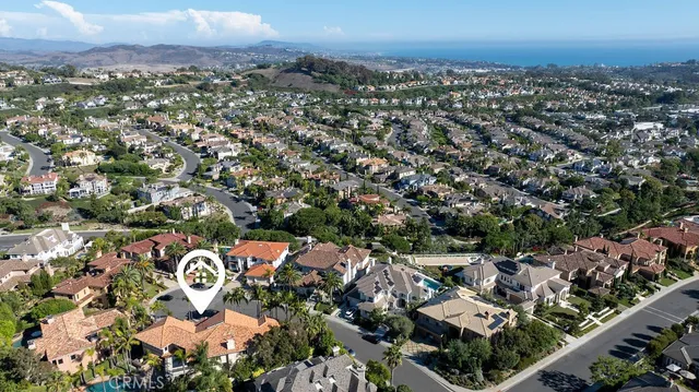 an aerial view of residential house with outdoor space and trees all around