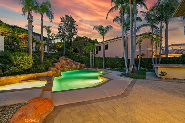 a backyard of a house with outdoor seating and palm tree