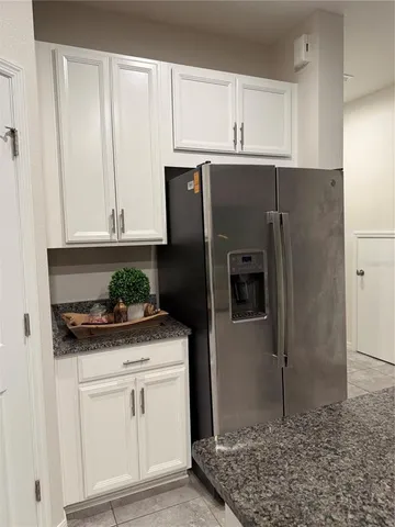 a kitchen with stainless steel appliances white cabinets and a refrigerator