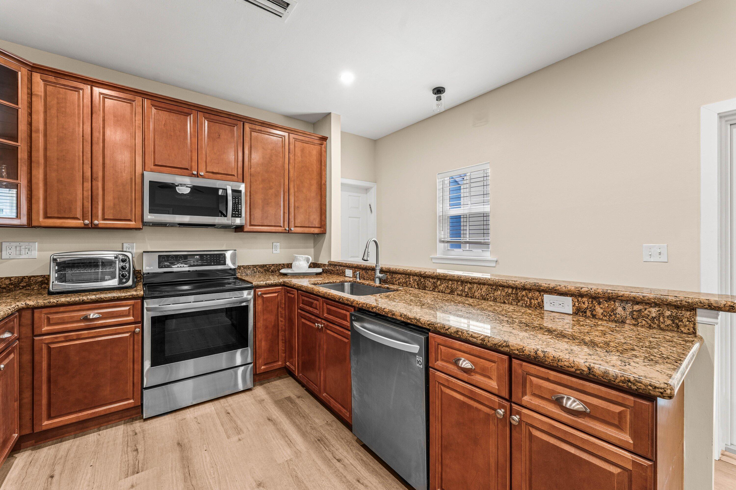 5908 Catesby Street Boca Raton, FL 33433 - Photo 12 of 49 a kitchen with granite countertop stainless steel appliances and wooden cabinets