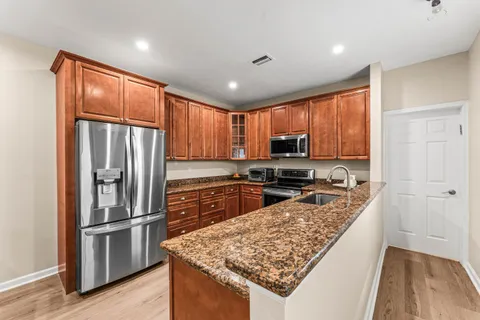 a kitchen with stainless steel appliances granite countertop a refrigerator stove and oven
