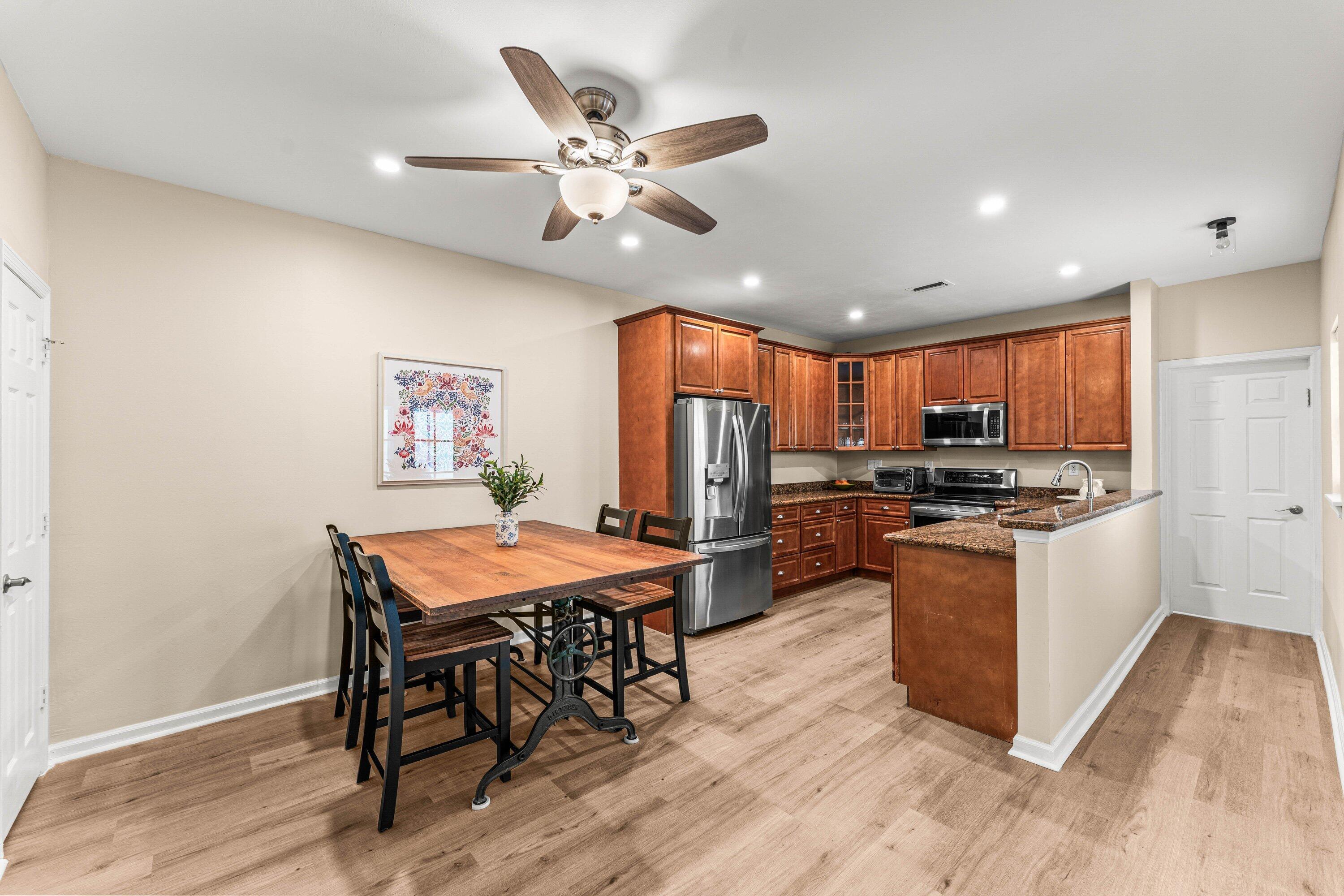 5908 Catesby Street Boca Raton, FL 33433 - Photo 14 of 49 a kitchen with stainless steel appliances kitchen island granite countertop a table chairs and a refrigerator