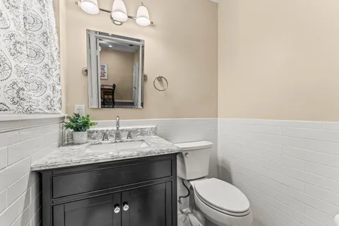 a bathroom with a granite countertop toilet sink and mirror