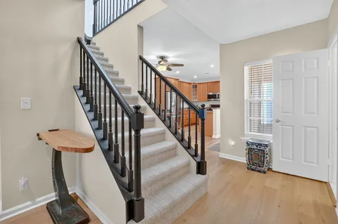 a view of a hallway with wooden floor and stairs