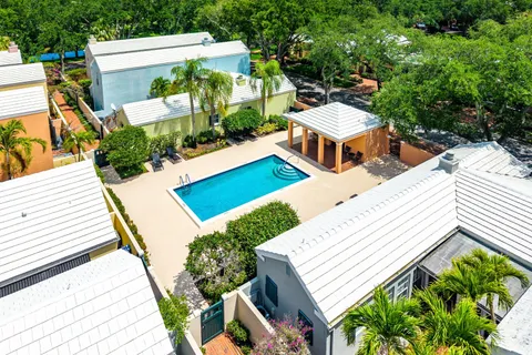 an aerial view of a house with swimming pool and large trees