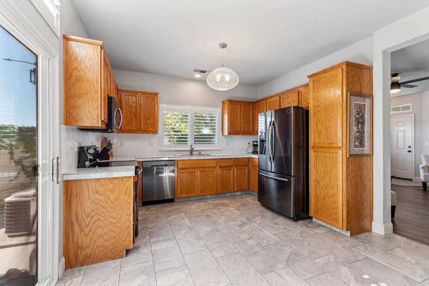 3300 Spring Garden Drive Turlock, CA 95382 - Photo 13 of 34 a kitchen with stainless steel appliances granite countertop a refrigerator a stove top oven and a sink