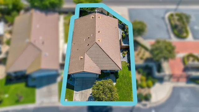 an aerial view of a house with a yard and lake view