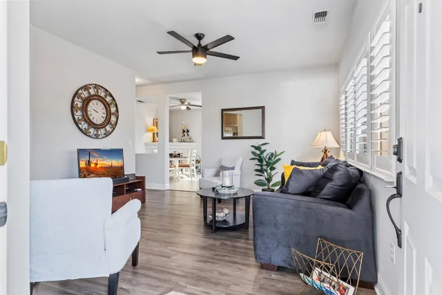 a living room with furniture a flat screen tv and a large window