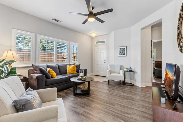 a living room with furniture and a wooden floor
