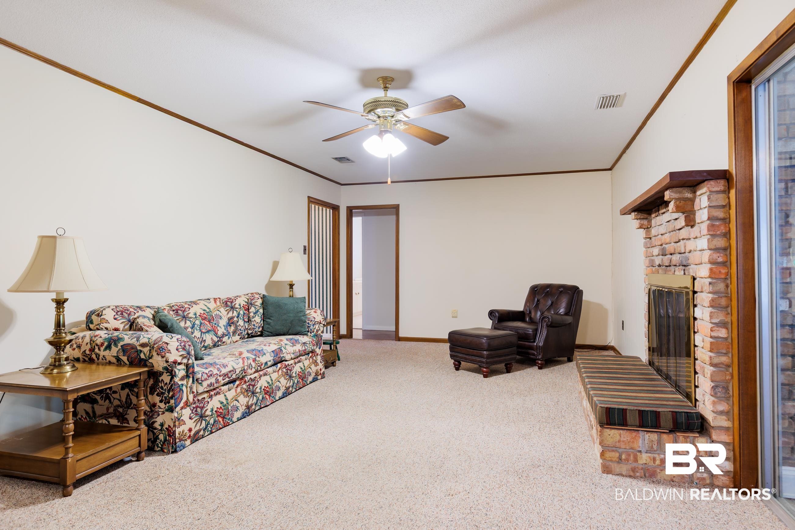 1367 Spring Valley Court Mobile, AL 36693 - Photo 3 of 29 Spacious living area featuring carpet flooring, a brick fireplace with a wood mantel, and sliding glass doors