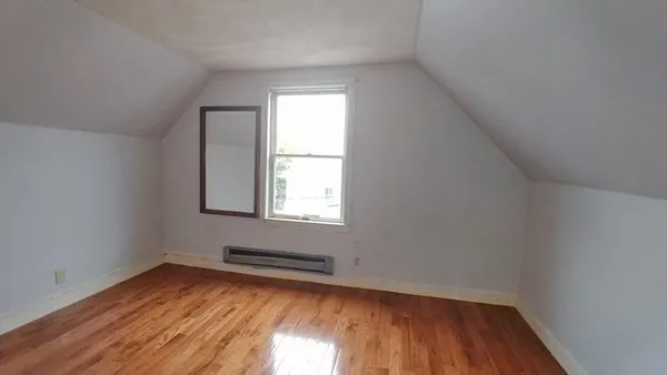 a view of a room with wooden floor and window