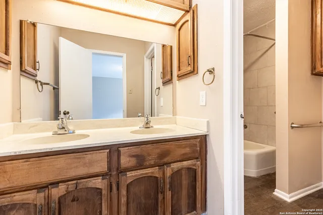 a bathroom with a granite countertop sink and a mirror
