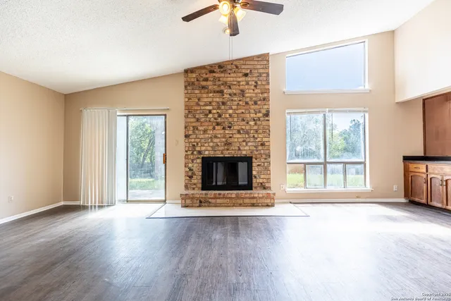 a view of an empty room with a window and fireplace