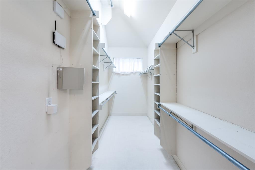 3752 Park Place Addison, TX 75001 - Photo 20 of 25 Spacious walk-in closet featuring extensive built-in shelving and hanging rods, a window for natural light, and recessed lighting