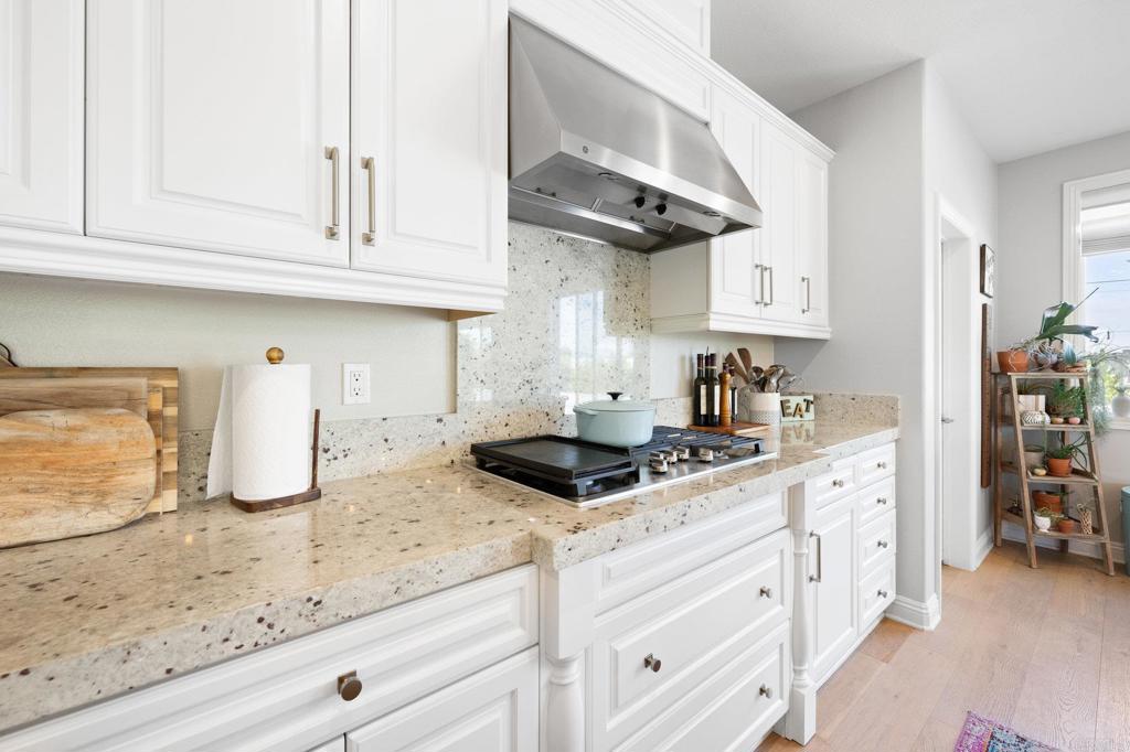 1211 Tesoro Place Vista, CA 92081 - Photo 15 of 57 a kitchen with granite countertop white cabinets and white appliances