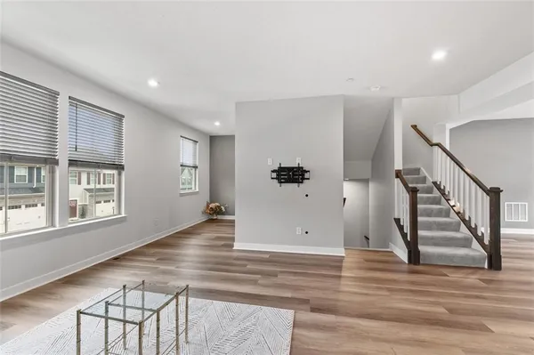 a view of a hallway with wooden floor and staircase