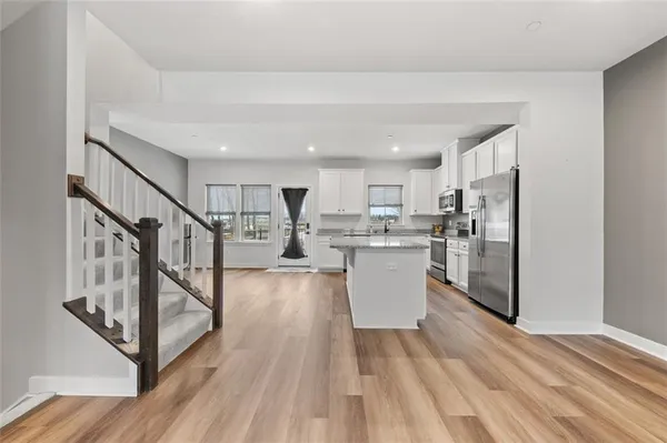 a view of a livingroom with wooden floor and stairs