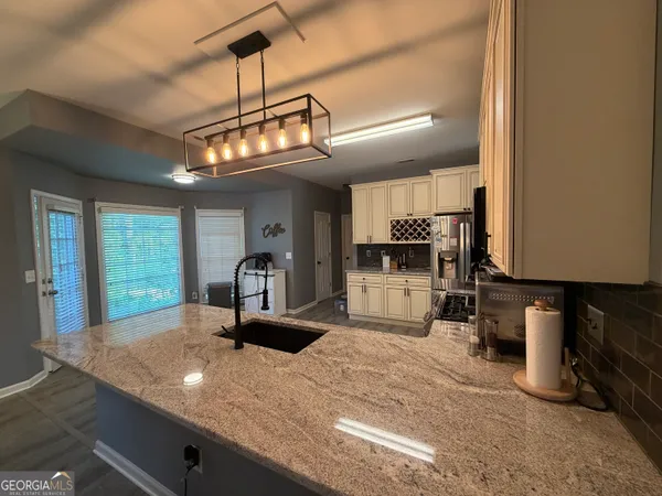 a kitchen with granite countertop a sink cabinets and wooden floor