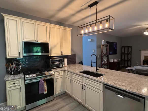 a kitchen with stainless steel appliances granite countertop a sink and a stove