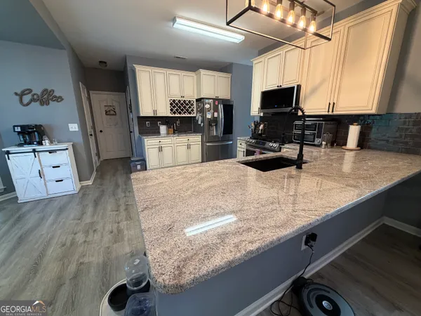 a kitchen with stainless steel appliances kitchen island granite countertop a stove a sink and a microwave