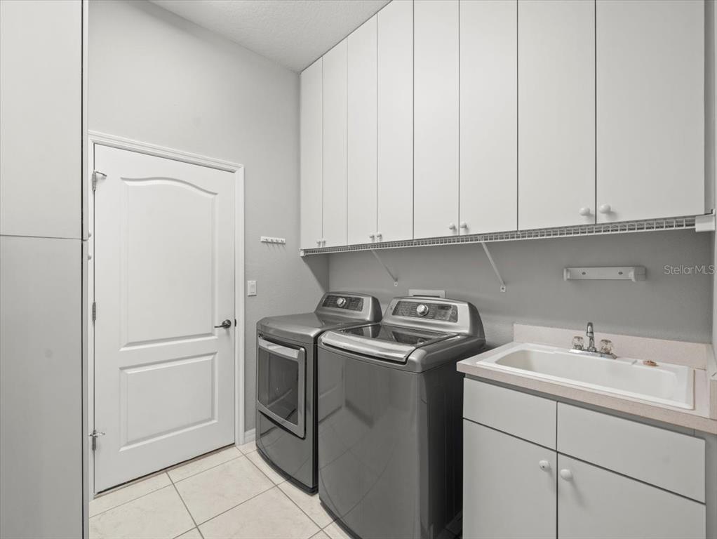 9037 Penelope Drive Weeki Wachee, FL 34613 - Photo 38 of 60 a view of cabinets and utility room with washer and dryer