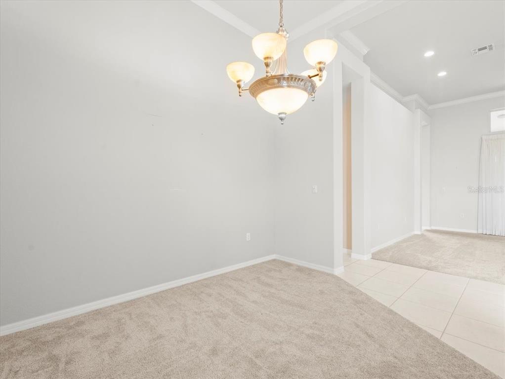 9037 Penelope Drive Weeki Wachee, FL 34613 - Photo 10 of 60 an empty room with a chandelier fan and a chandelier fan