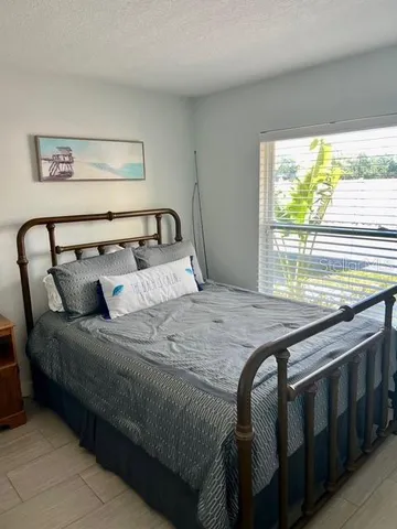 a bed sitting in a bedroom next to a window