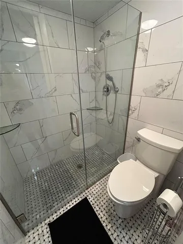 a bathroom with a granite countertop sink a toilet and mirror