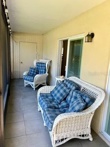 a view of a swimming pool with lawn chairs under an umbrella