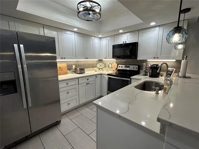a kitchen with stainless steel appliances a refrigerator sink and microwave