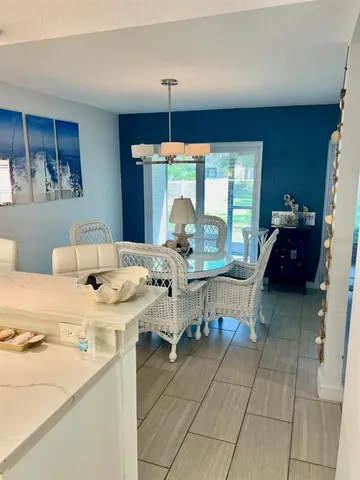 a room with a table chairs and a view of kitchen
