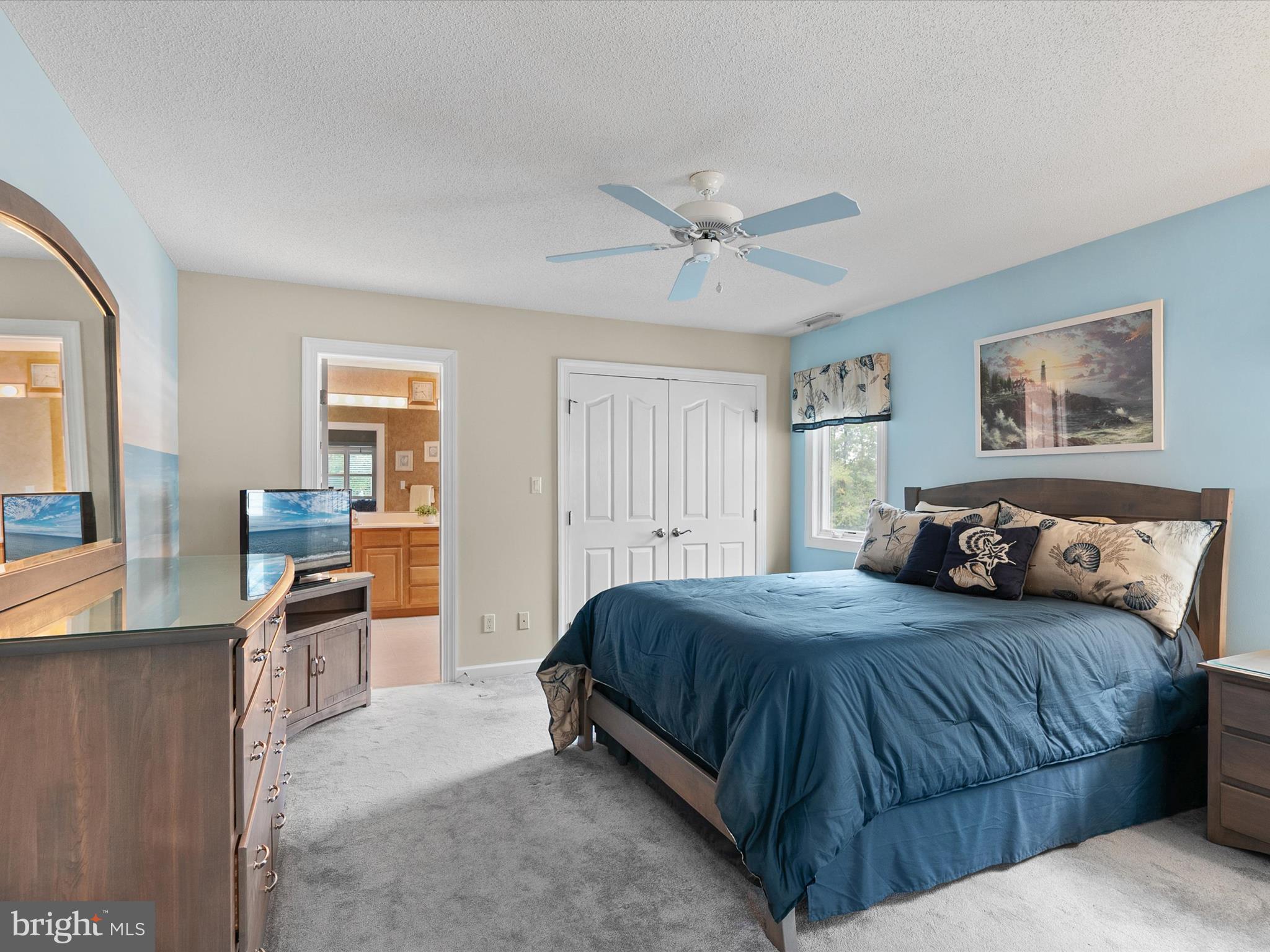 982 Turtle Drive Bethany Beach, DE 19930 - Photo 29 of 73 a bedroom with a large bed a chandelier and windows