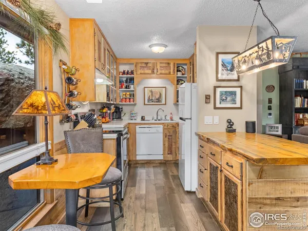 a kitchen with stainless steel appliances a stove a sink a dining table and chairs