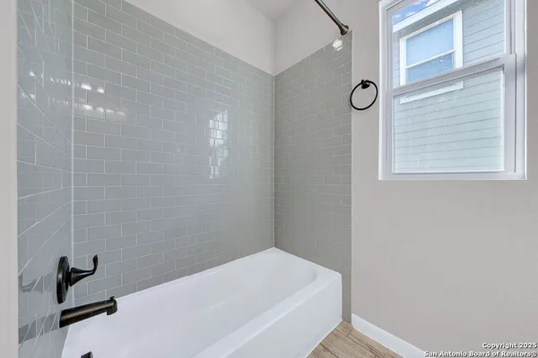 a bathroom with a bathtub and a window