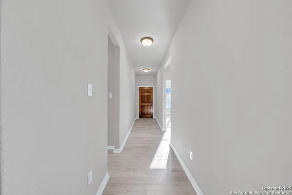 a view of a hallway with wooden shelves
