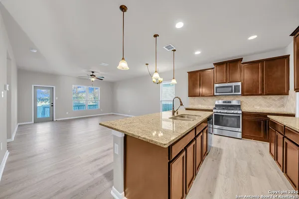 a kitchen with a center island wooden floor stainless steel appliances and a counter top space