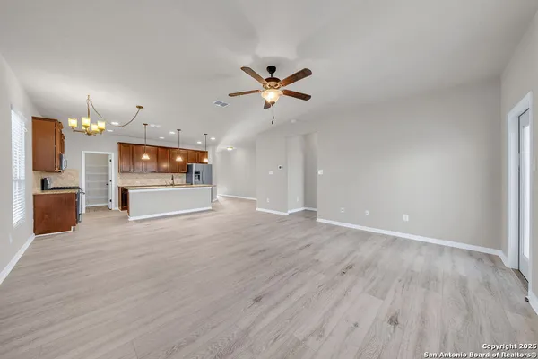 wooden floor in an empty room with a kitchen