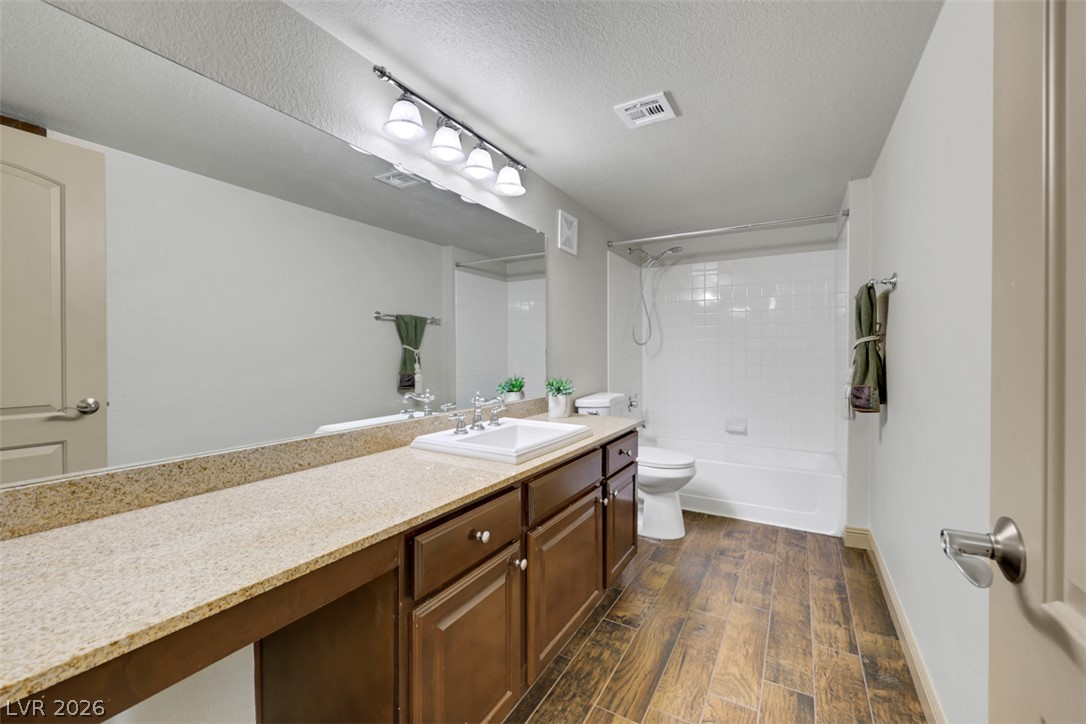 8101 West Flamingo Road, Unit 2136 Las Vegas, NV 89147 - Photo 24 of 32 Rich wood plank flooring accents a spacious vanity area next to the classic tub shower.